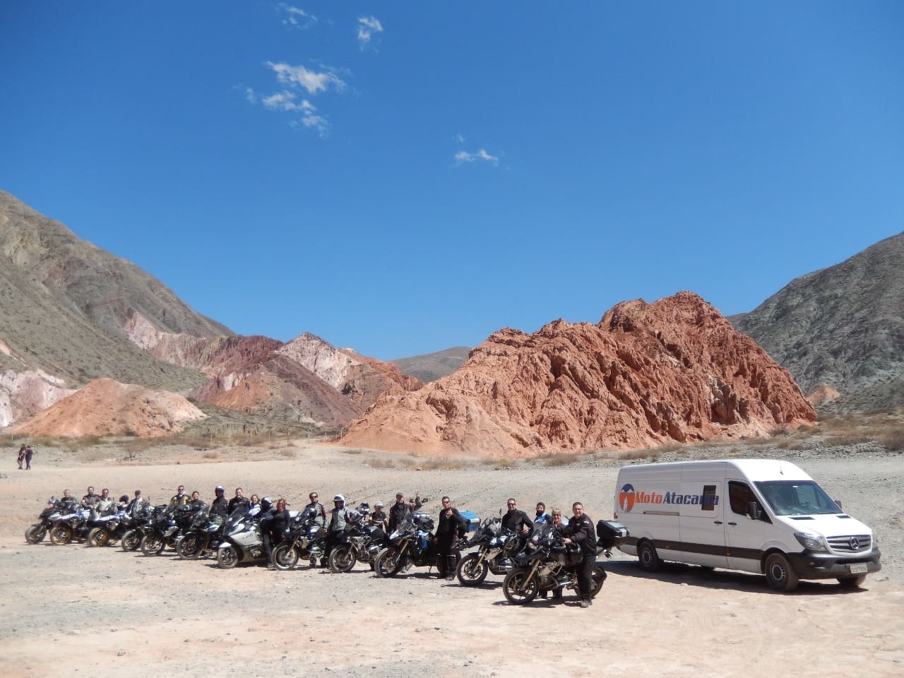 Grupo de motociclistas enfileirados ao lado de uma van de apoio da MotoAtacama
